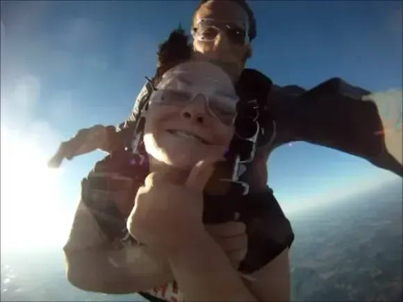 happy tandem student jumping for the first time at our kansas city drop zone during a pretty spring day