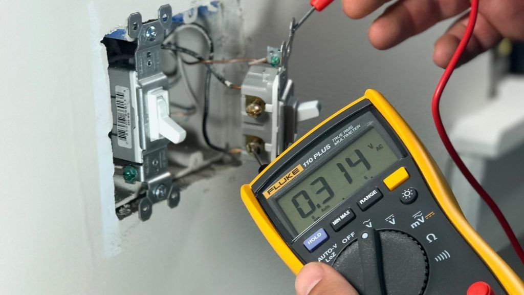 Hands testing electronic circuits with a multimeter.