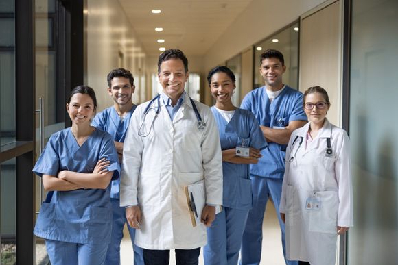 Medical Professionals - San Diego, CA - Andy Van Lee & Associates, PC Medical professionals standing in a hallway, smiling. Some in scrubs, others in white coats.
