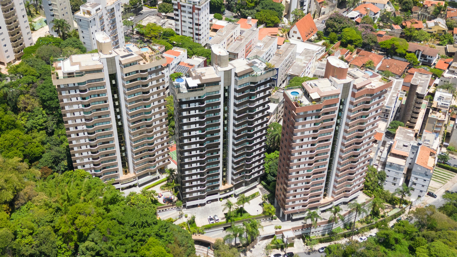 Aerial view of high-rise condominium towers surrounded by trees