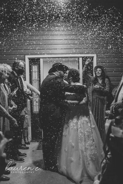 Couple embracing at a snowy nighttime wedding ceremony under twinkling lights