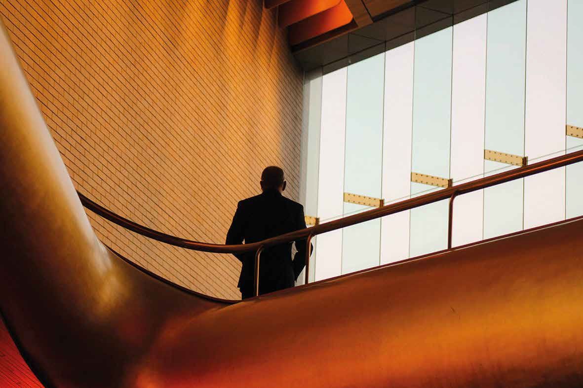 Ein Mann im Anzug geht in einem Gebäude eine Treppe hinauf.
