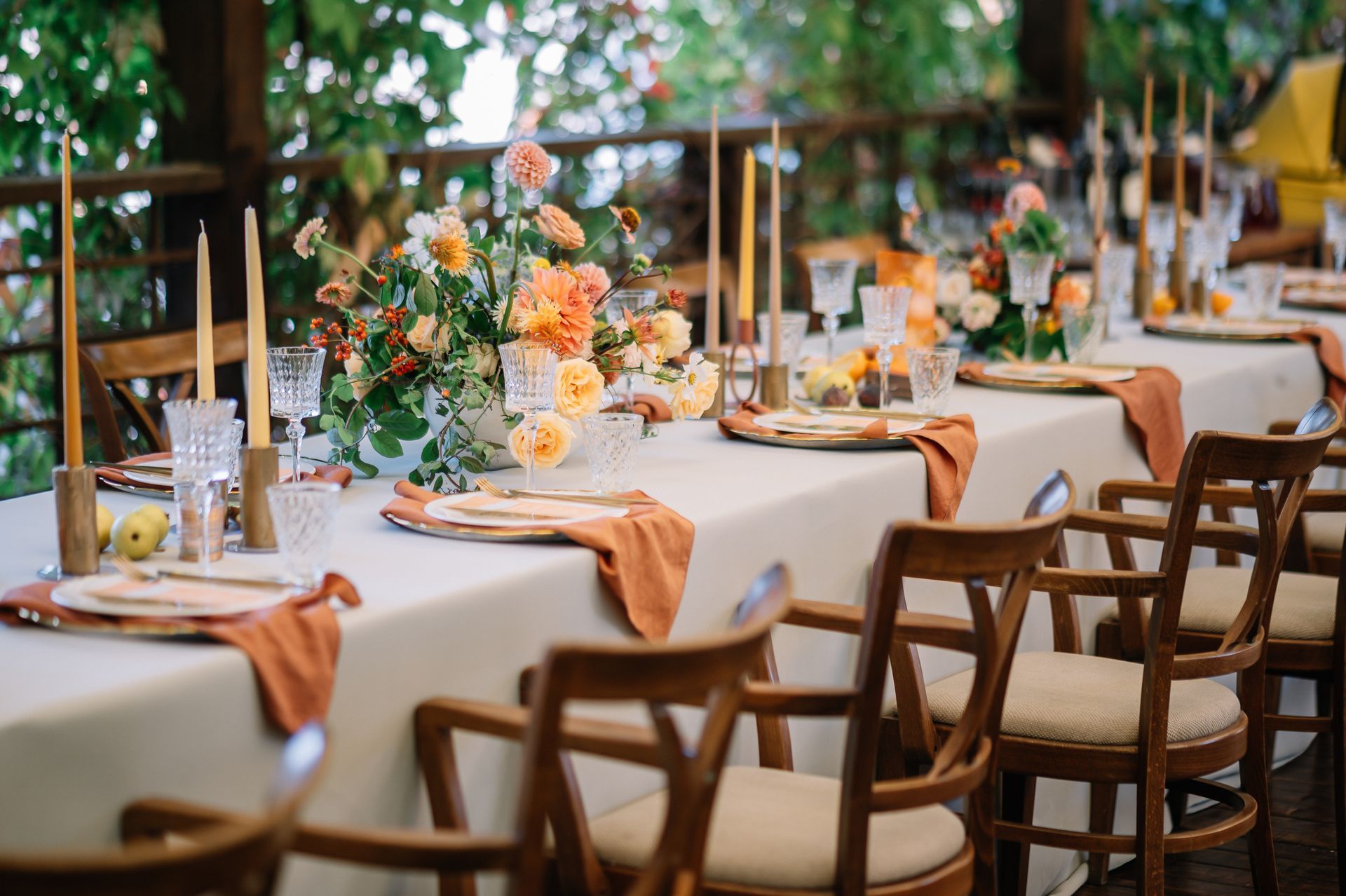 Long table set for a wedding reception with orange flowers