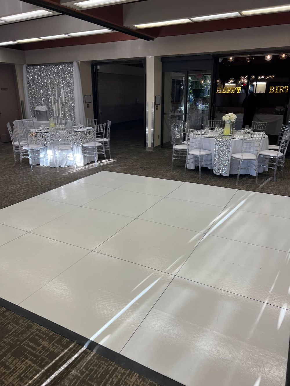 White dance floor with tables set for an event