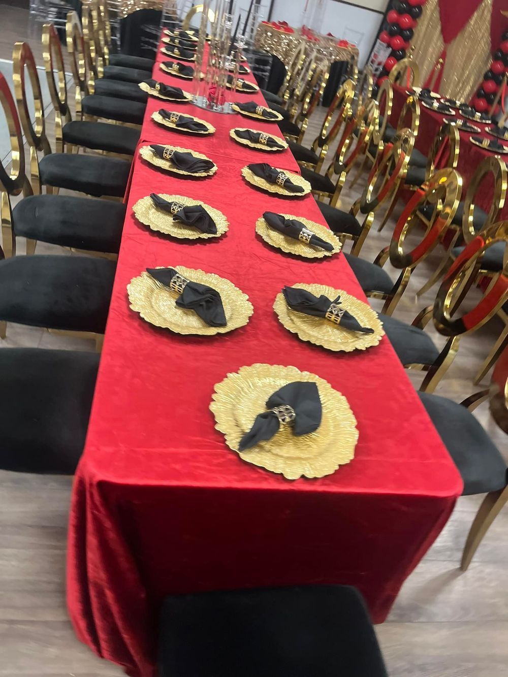 Long red banquet table with gold chargers