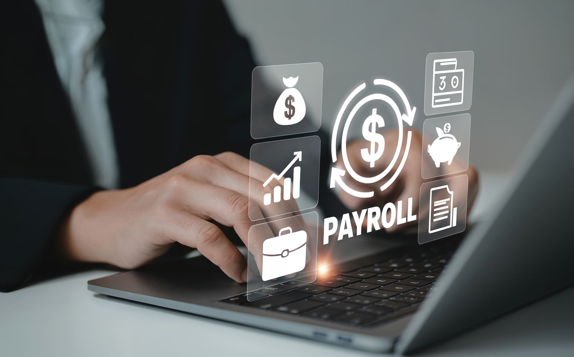 Hands typing on a laptop with payroll and finance icons glowing above the keyboard