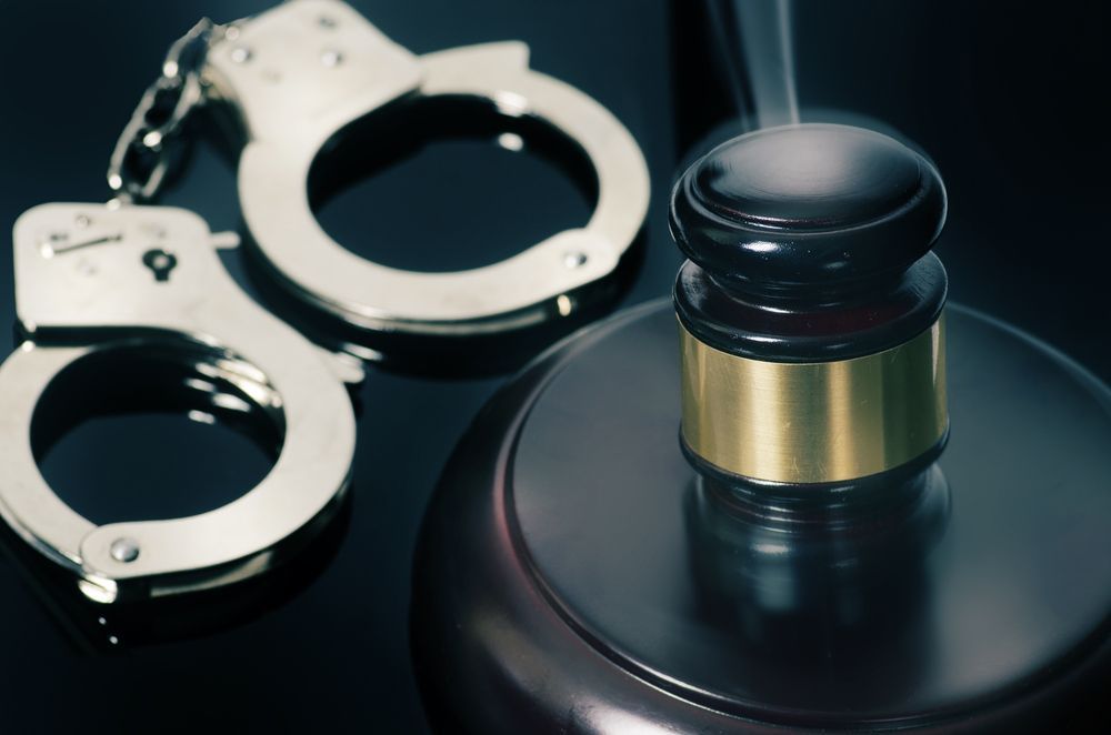 A pair of handcuffs sitting next to a judge 's gavel