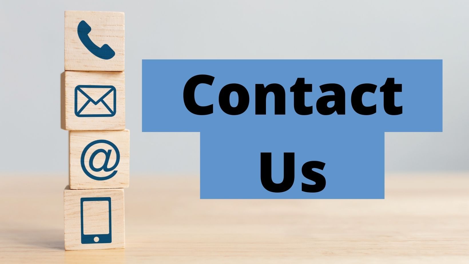 Blue “Contact Us” sign beside stacked wooden blocks with phone, email, @, and mobile icons.