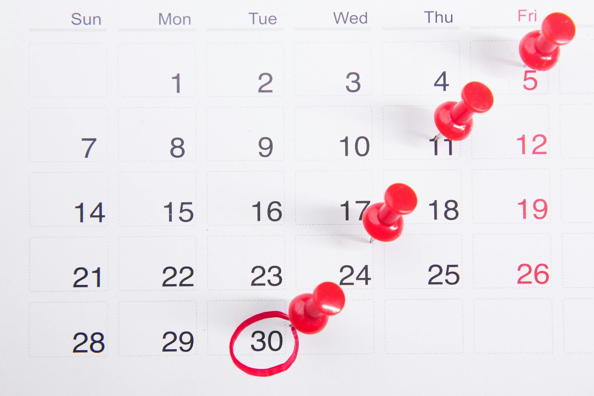 Calendar page with red pushpins marking a countdown to the circled 30th date.