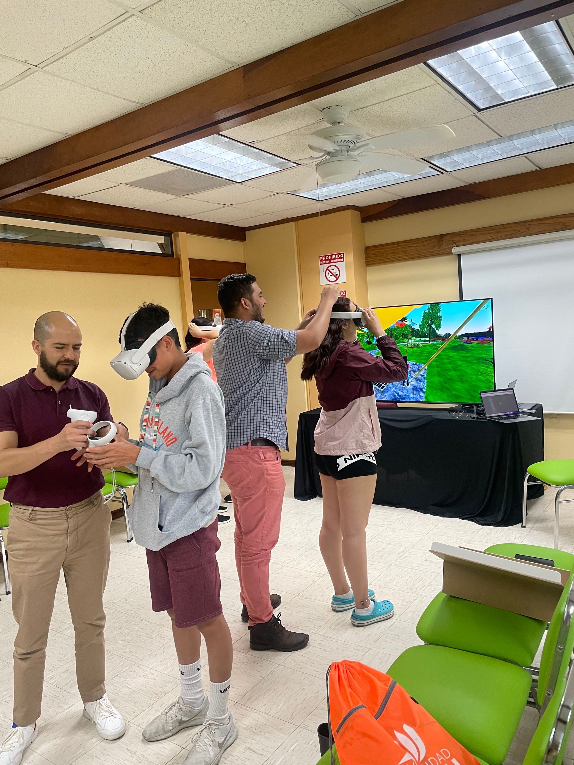 Un grupo de personas se encuentran en una habitación usando cascos de realidad virtual.