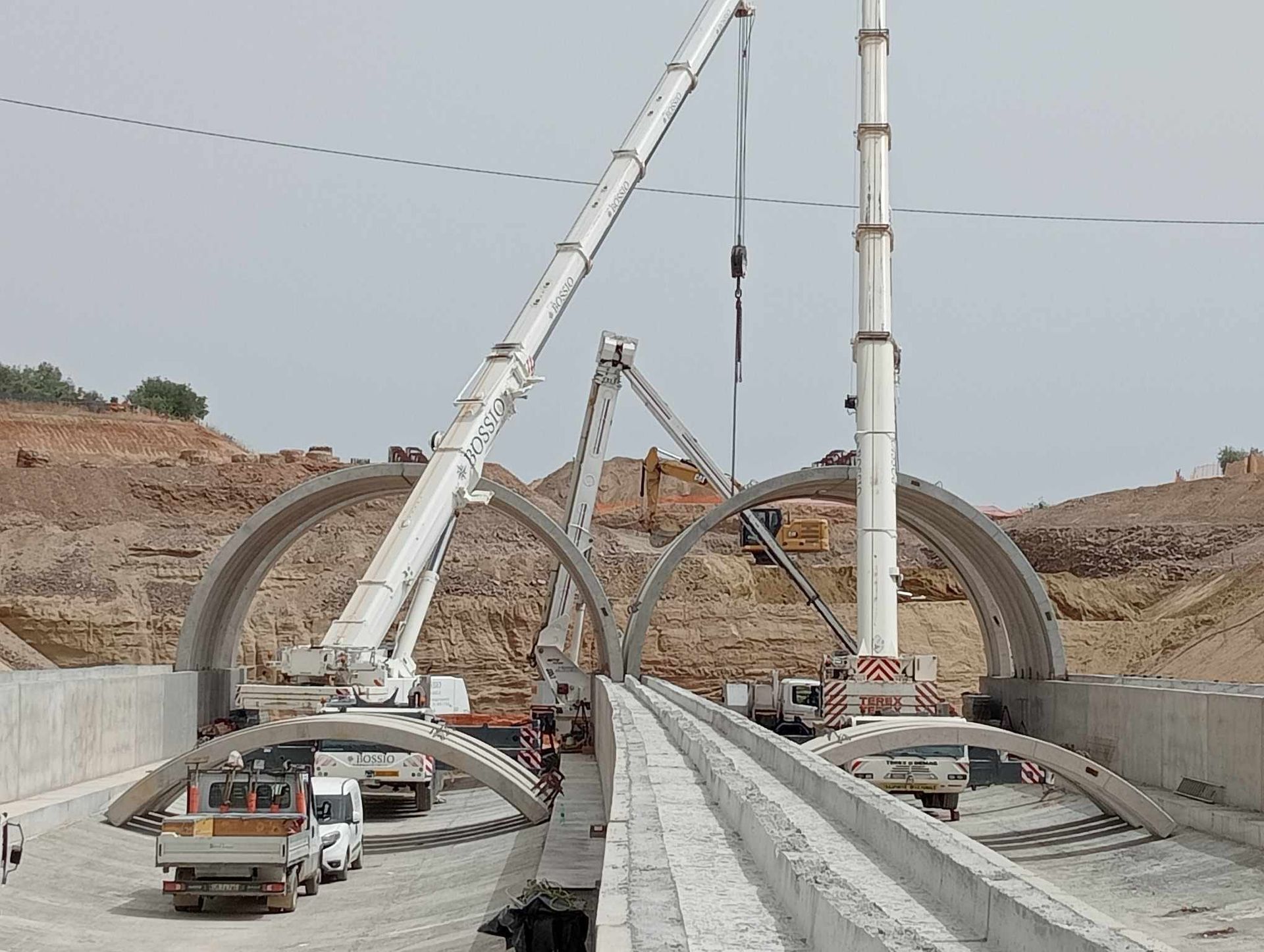 Un cantiere con molti camion e gru
