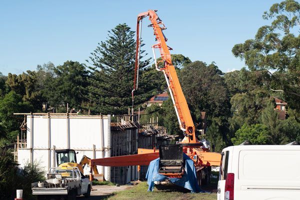 A large excavator is sitting on top of a pile of dirt on a construction site.