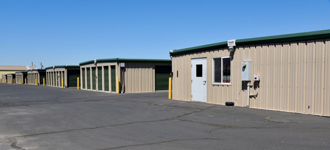 A row of storage units are lined up in a parking lot.