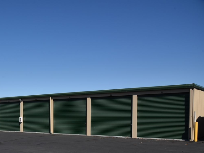 A row of green garage doors with numbers on them