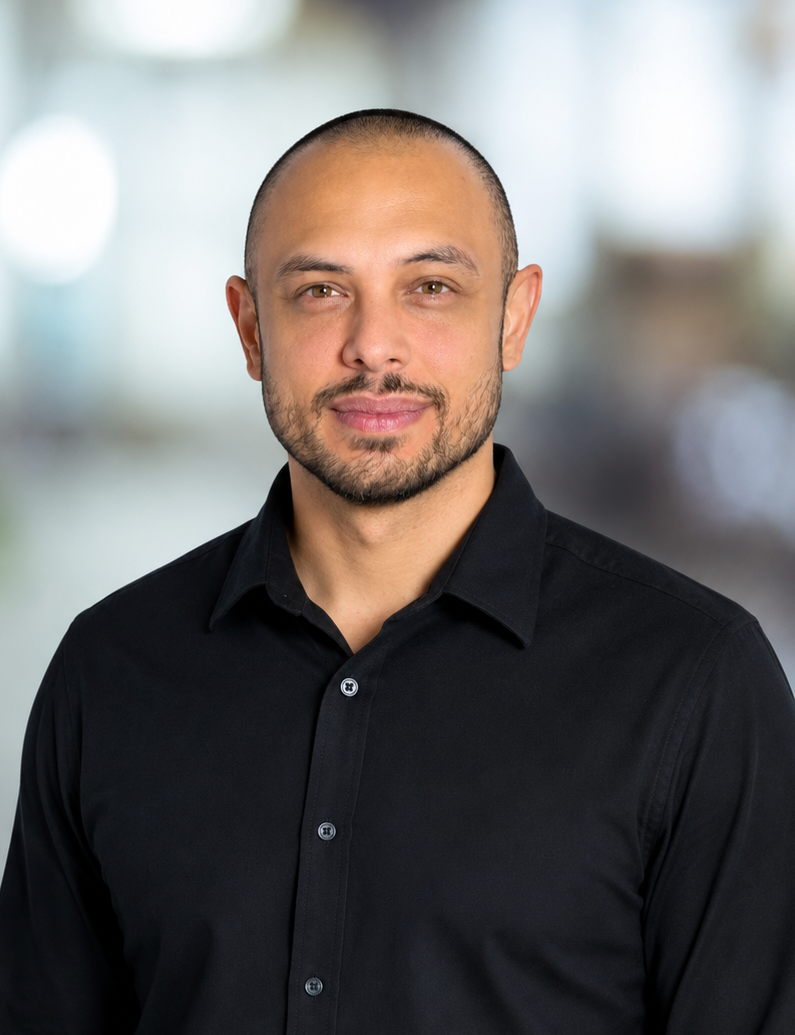 Portrait of a man in a black shirt against a blurred office background