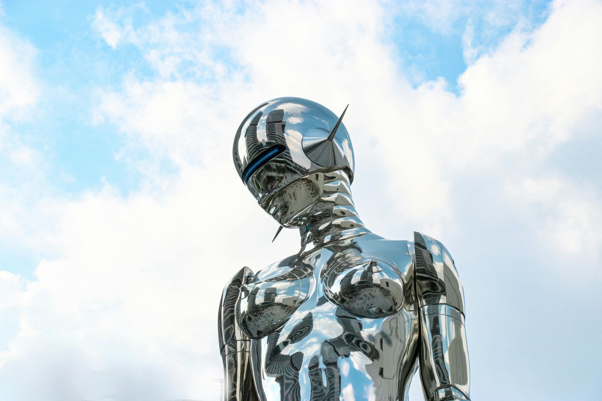 An ai robot standing in front of a cloudy sky.