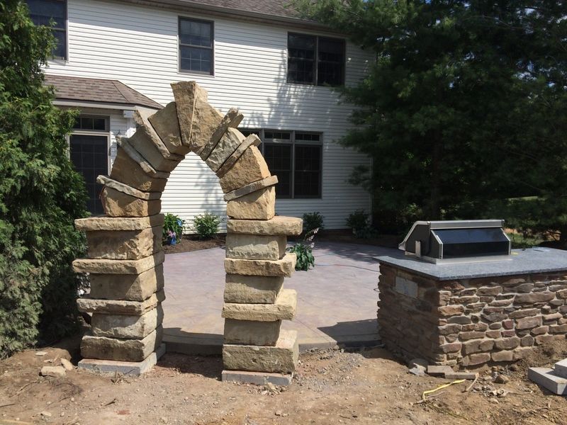 A stone archway with a grill in front of a house