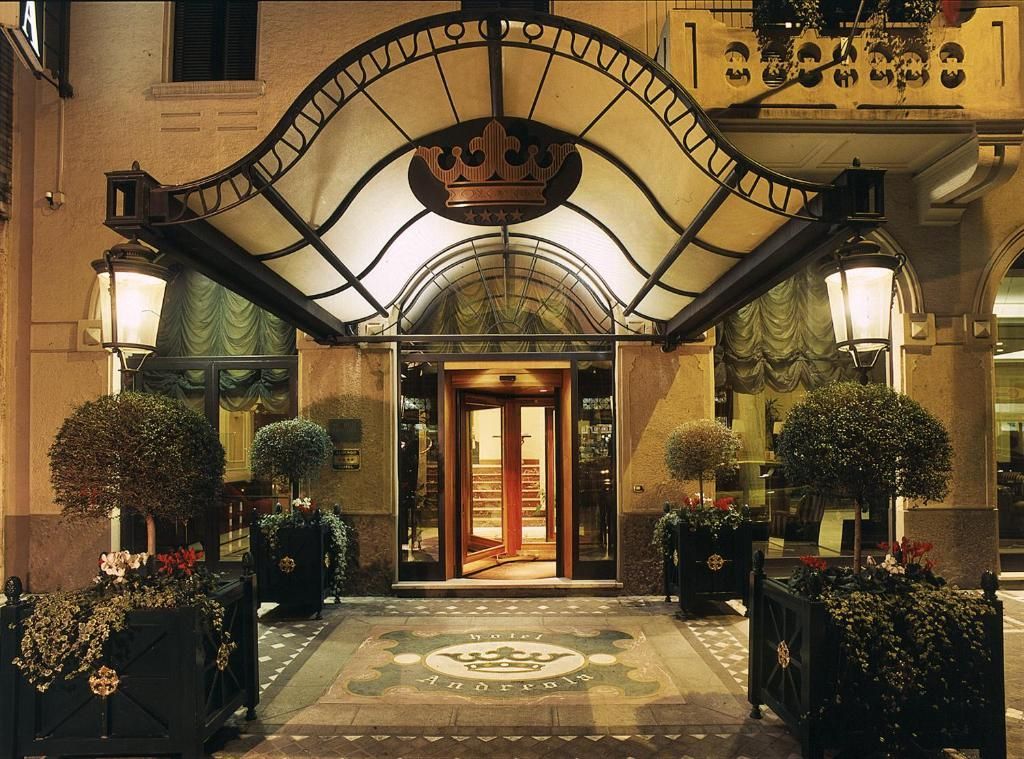 Intrarea hotelului Andreola Central Hotel din Milano, cu o cupolă elegantă și detalii arhitecturale Art Neuveau.