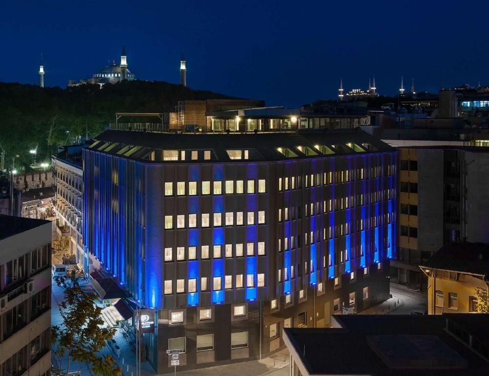Vedere panoramică nocturnă a hotelului DoubleTree by Hilton Istanbul Sirkeci, cu fatada complet iluminata.