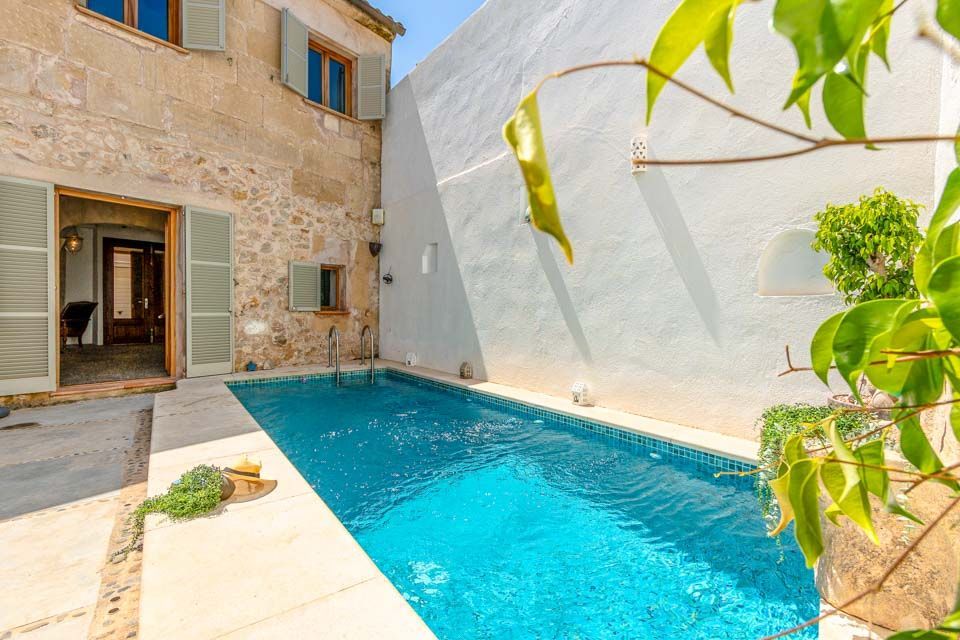 Vedere asupra piscinei private din curtea interioară a vilei Casa Albuqassim, în inima orașului Pollença, Mallorca, Spania.