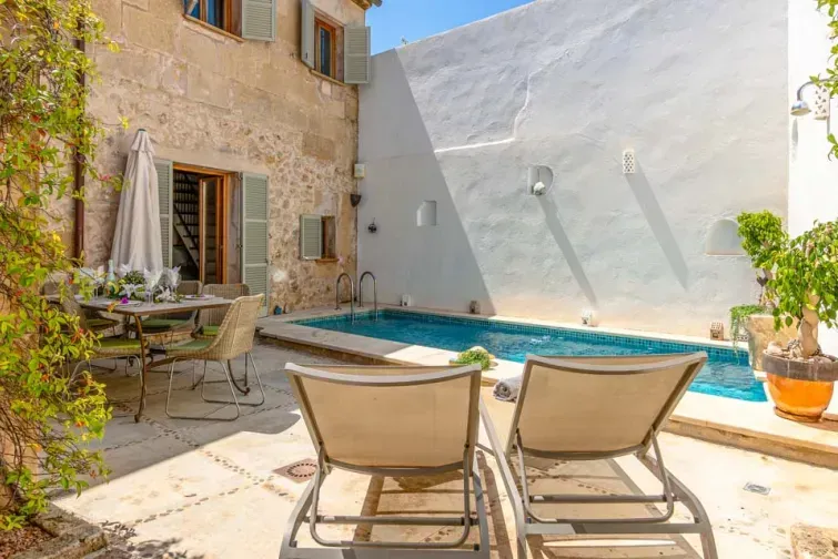 Curtea interioară a vilei Albuqassim, cu piscină, plante decorative, șezlonguri și un aspect spaniol rustic. 