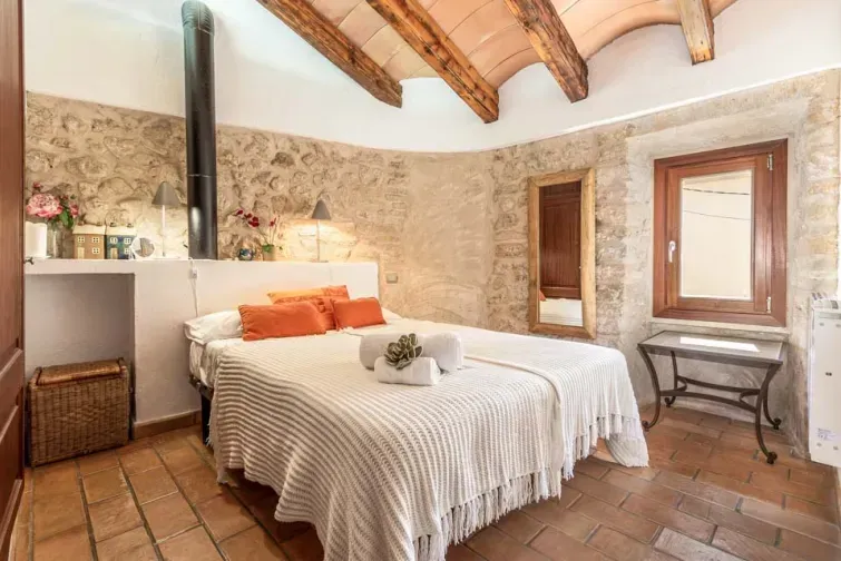 Unul dintre dormitoarele vilei Albuqassim din Mallorca. Pereții sunt din cărămidă și toată camera are un decor stilat, mediteranean. 