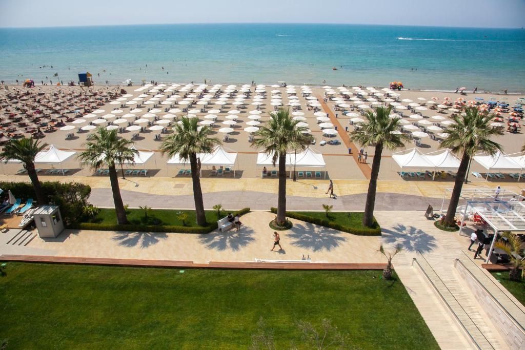 Priveliște asupra plajei private a hotelului Beach Durrës, cu zona de șezlonguri și apele cristaline ale mării în prim-plan. Peisajul surprinde liniștea și frumusețea litoralului din Golem.