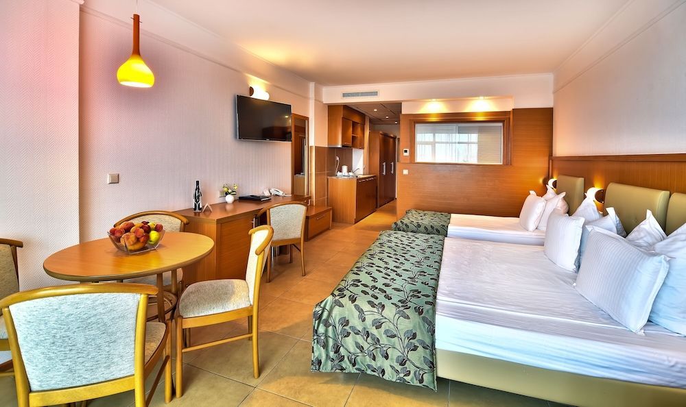 Camera eleganta cu pat dublu si mobilier de lemn masiv, la Hotelul si Spa-ul Flamingo Grand din Albena.