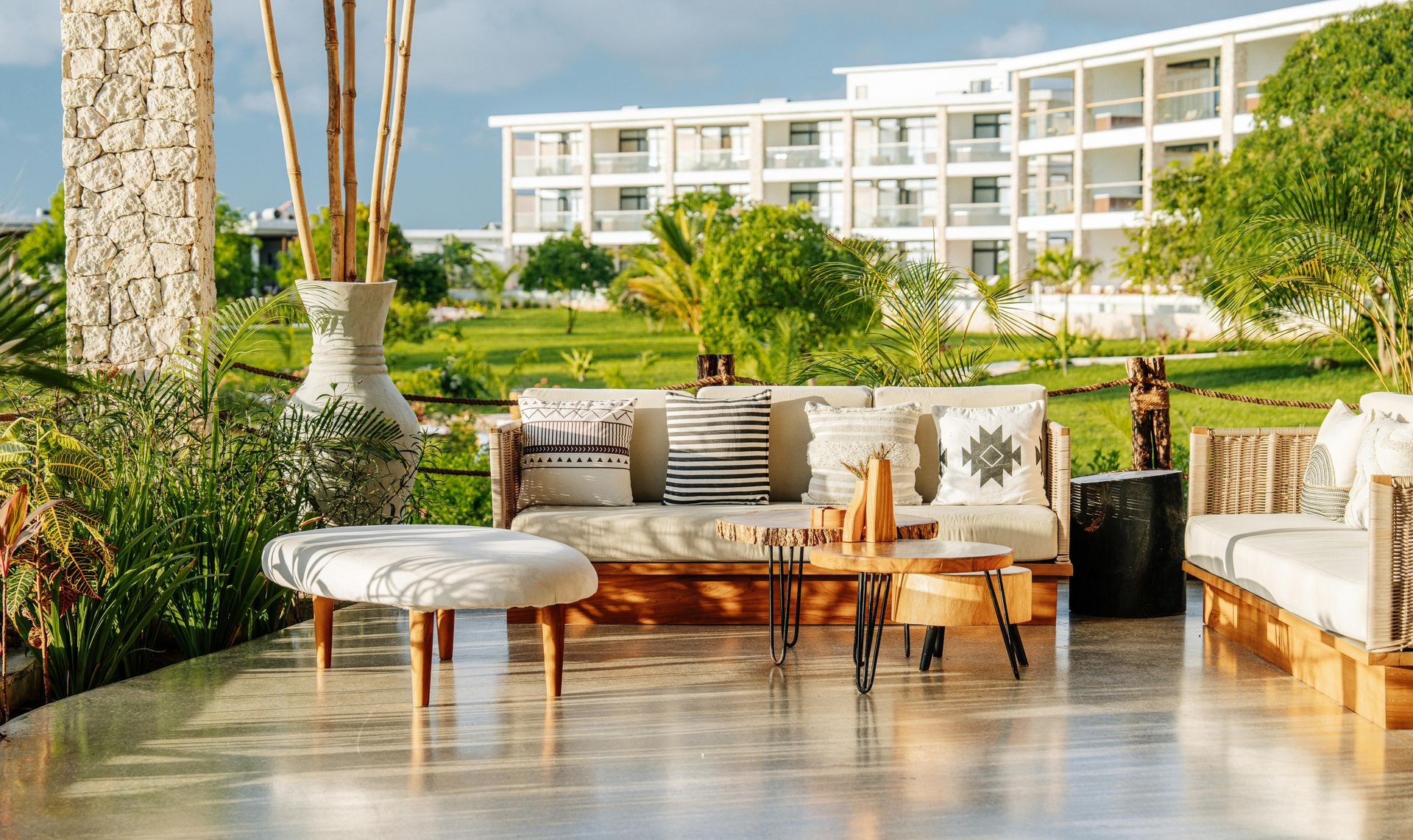 Spatiu de relaxare exterior în natură cu o masă, canapea si scaune la hotelul de cinci stele Riu Palace din Zanzibar.