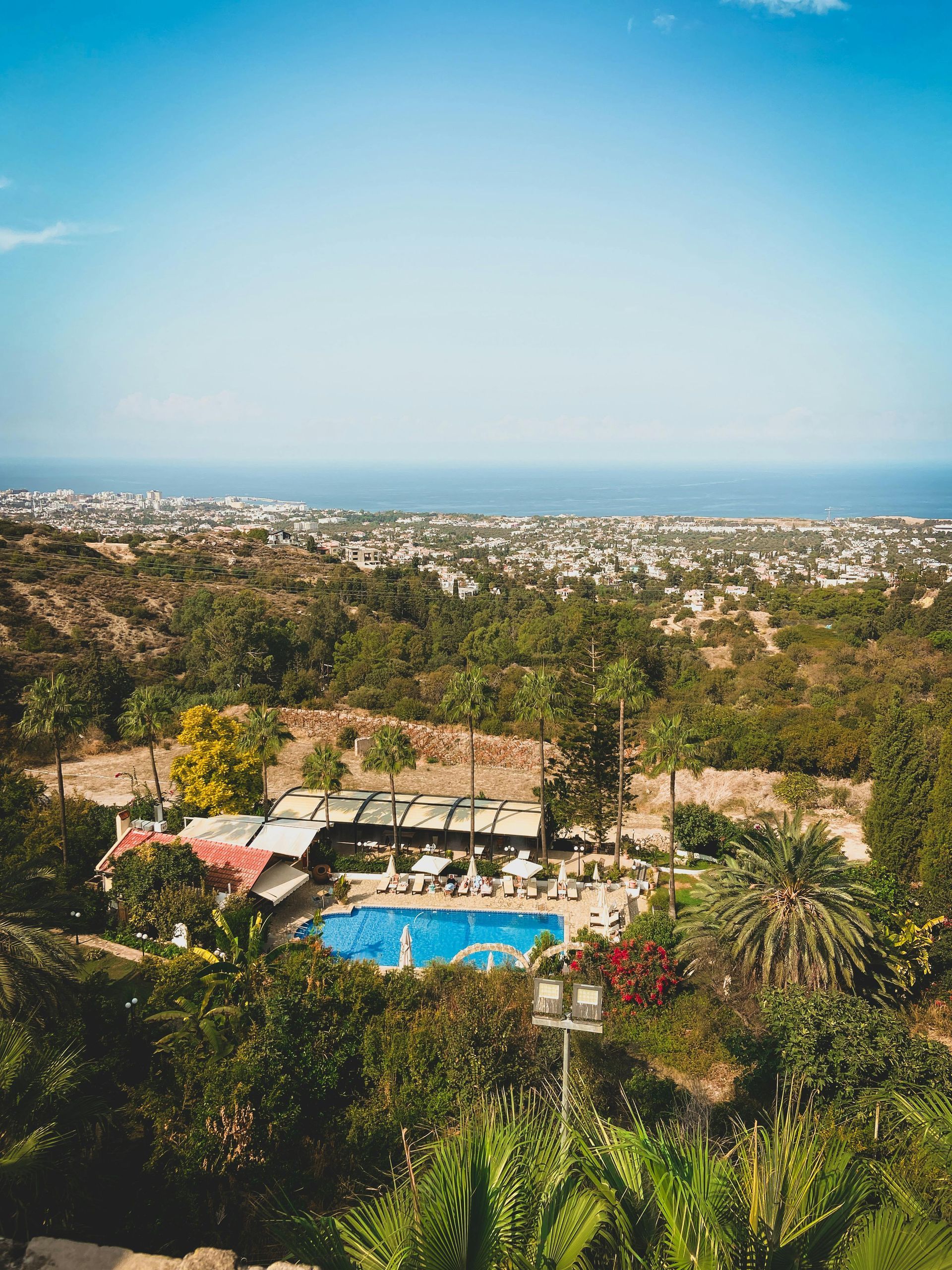 Vedere panoramică a vilei de vacanță cu piscină din Larnaca, Cipru. E înconjurată de palmieri și vegetație mediteraneană. Se află în apropierea plajei.