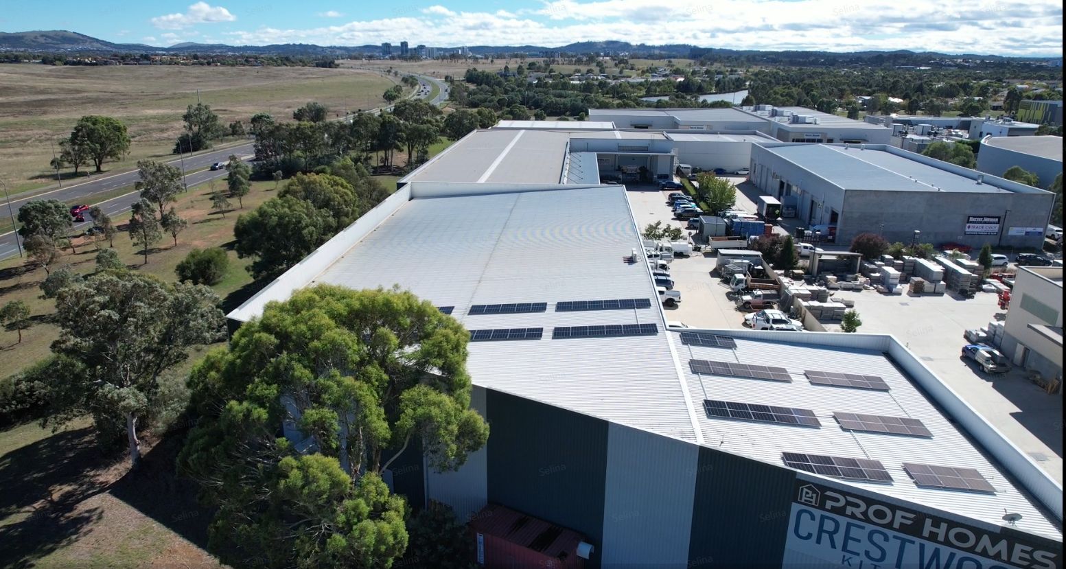 An aerial view of a large building with solar panels on the roof.