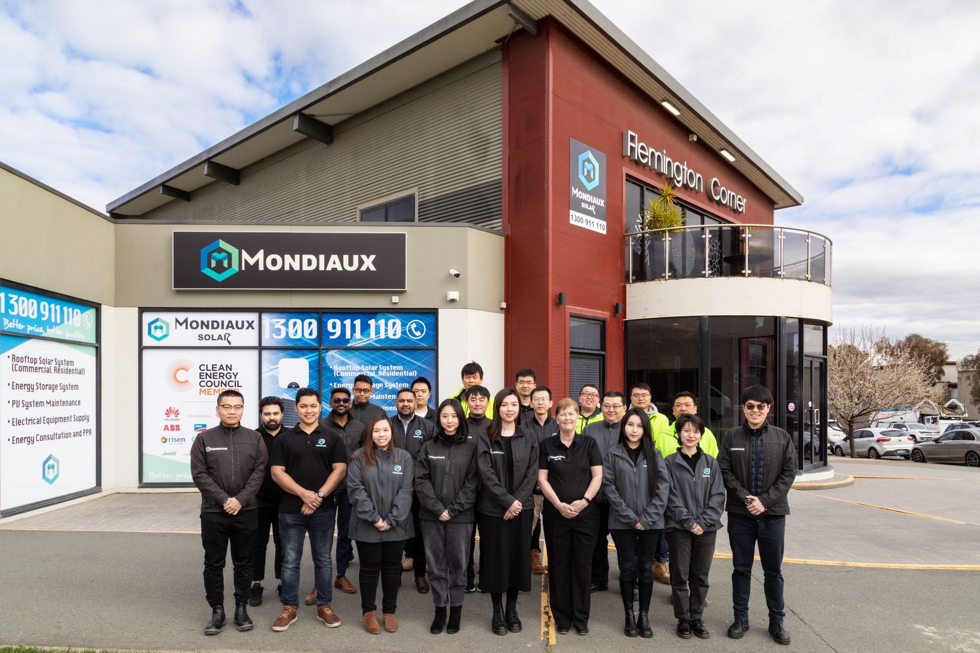 The mondiaux solar team are posing for a picture in front of a building.
