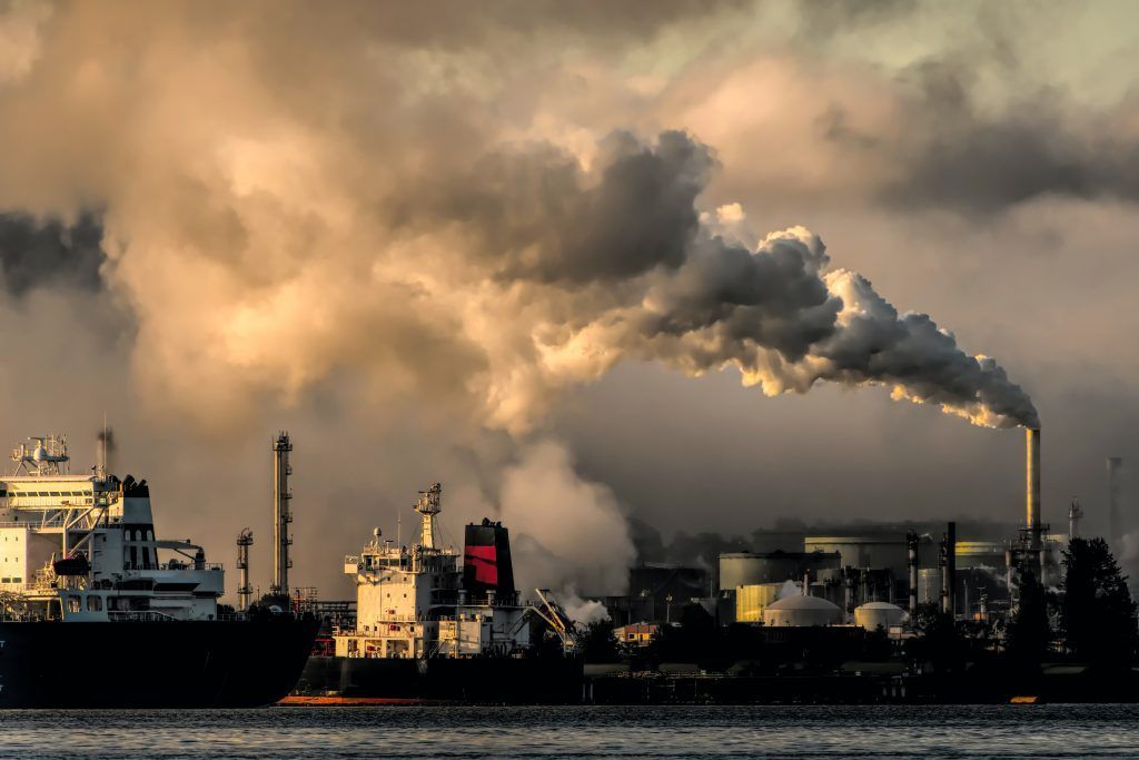A factory with smoke coming out of the chimneys.