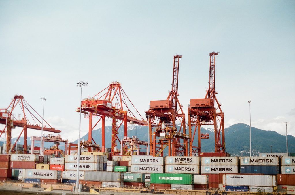 A harbor filled with lots of shipping containers and cranes.