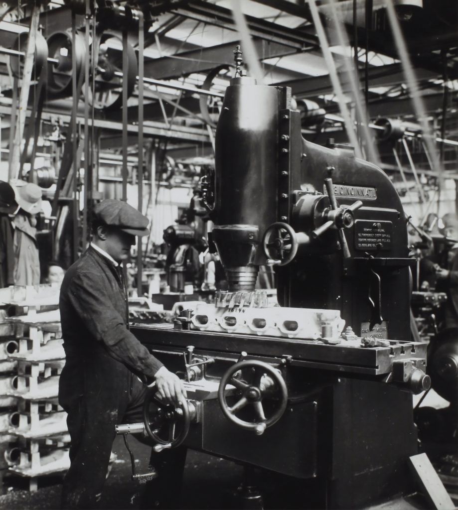 A black and white photo of a man working on a machine that says ' phoenix ' on it