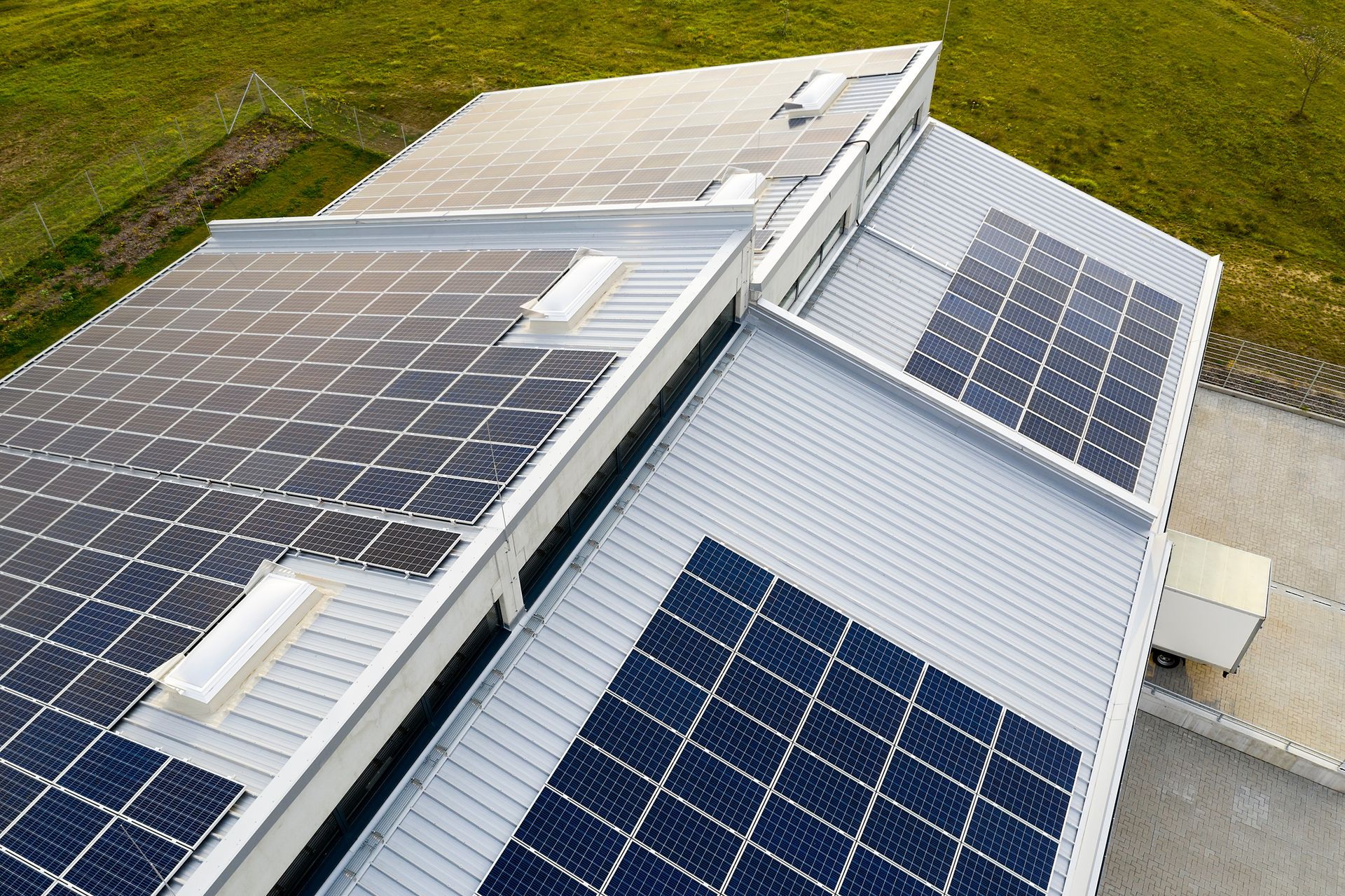 There are many solar panels on the roof of a building.