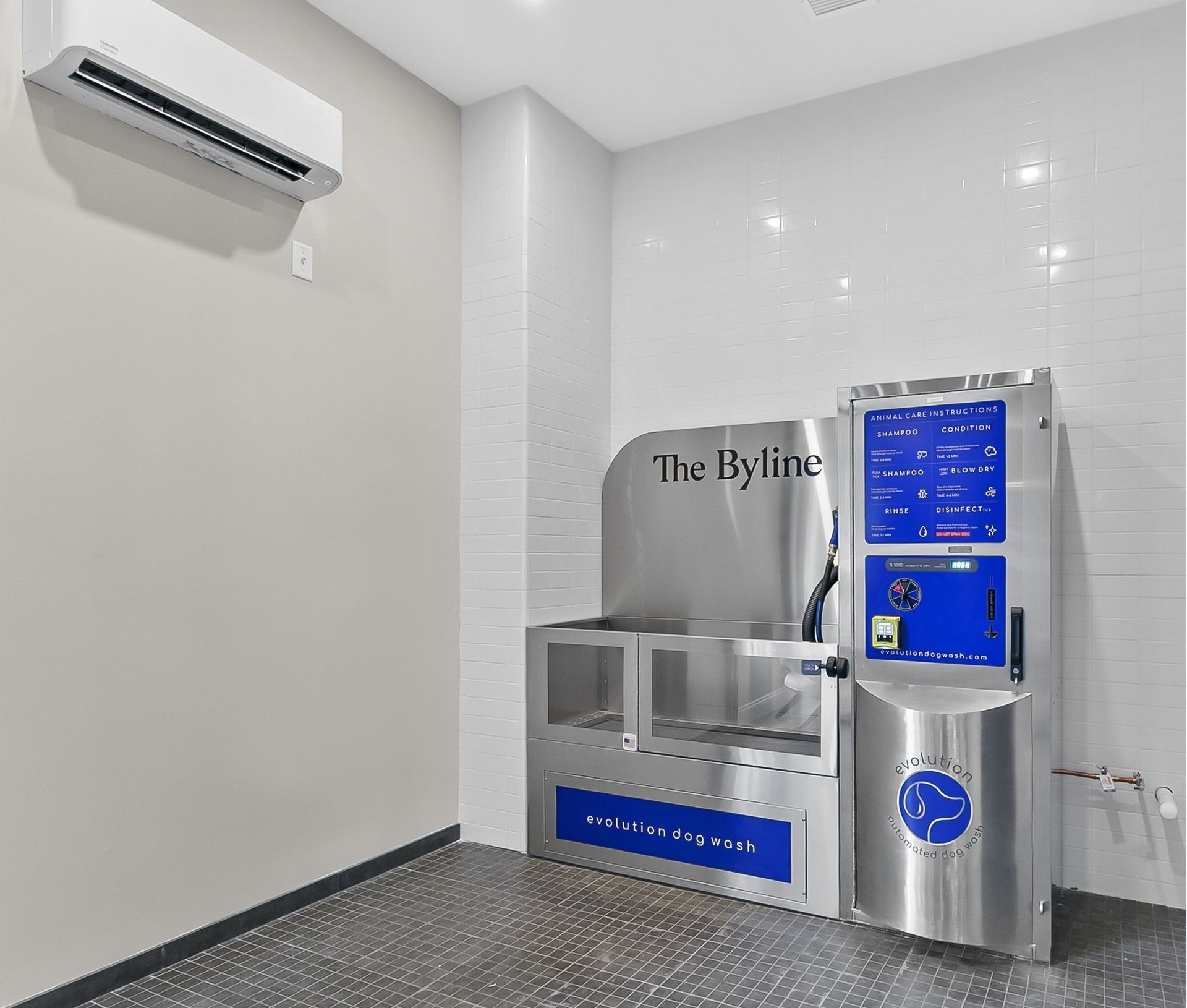 Bright indoor hallway with a stainless steel water refill station and a blue digital screen on a white wall.