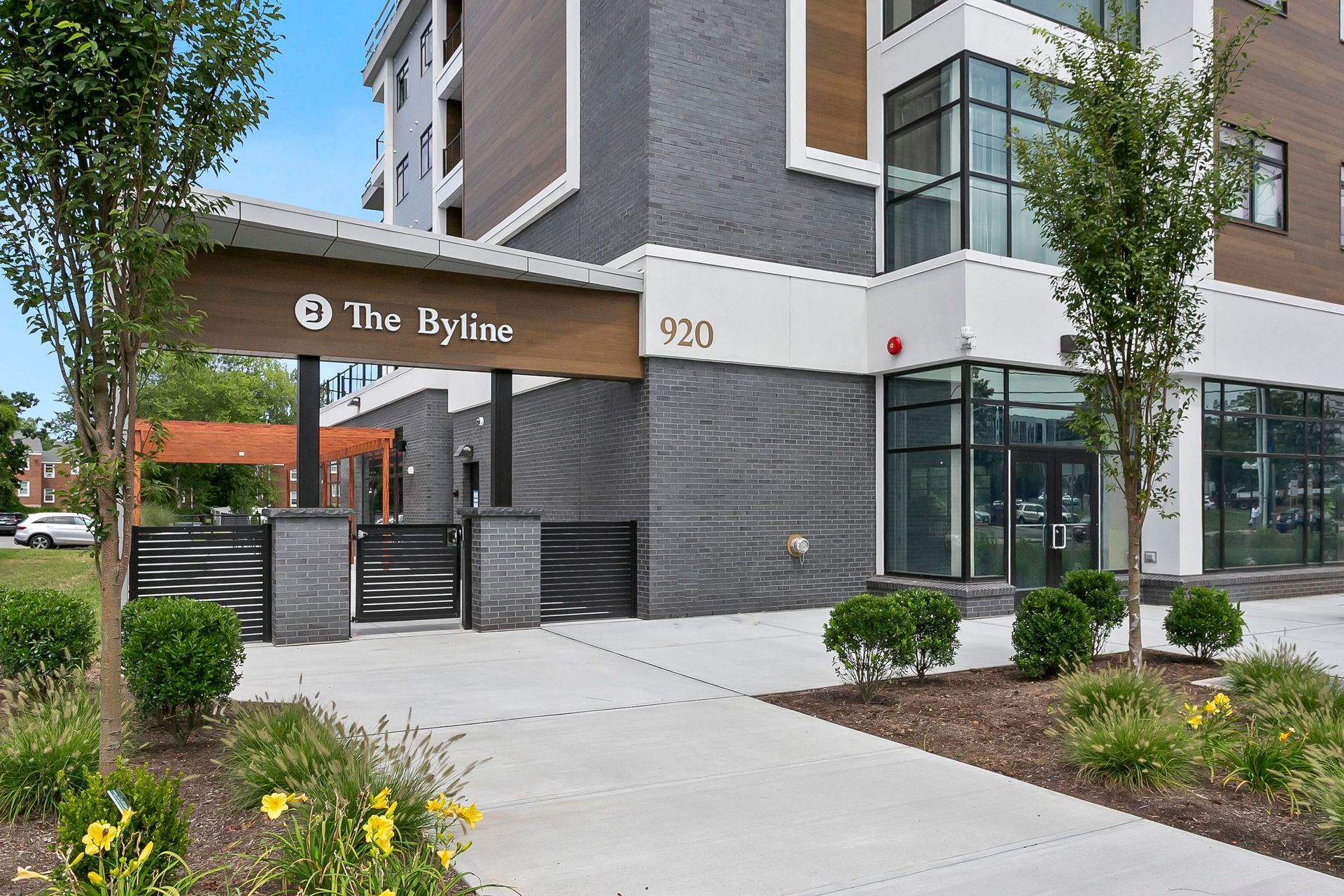 Apartment building entrance with sign reading “The Rylan” and address 700, beside a sidewalk and landscaping