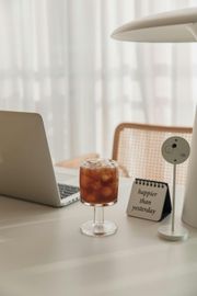 Laptop, iced coffee, desk lamp, and
