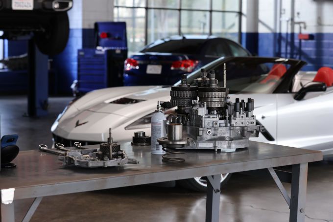 Mechanical gear on a table with a white corvette in the back