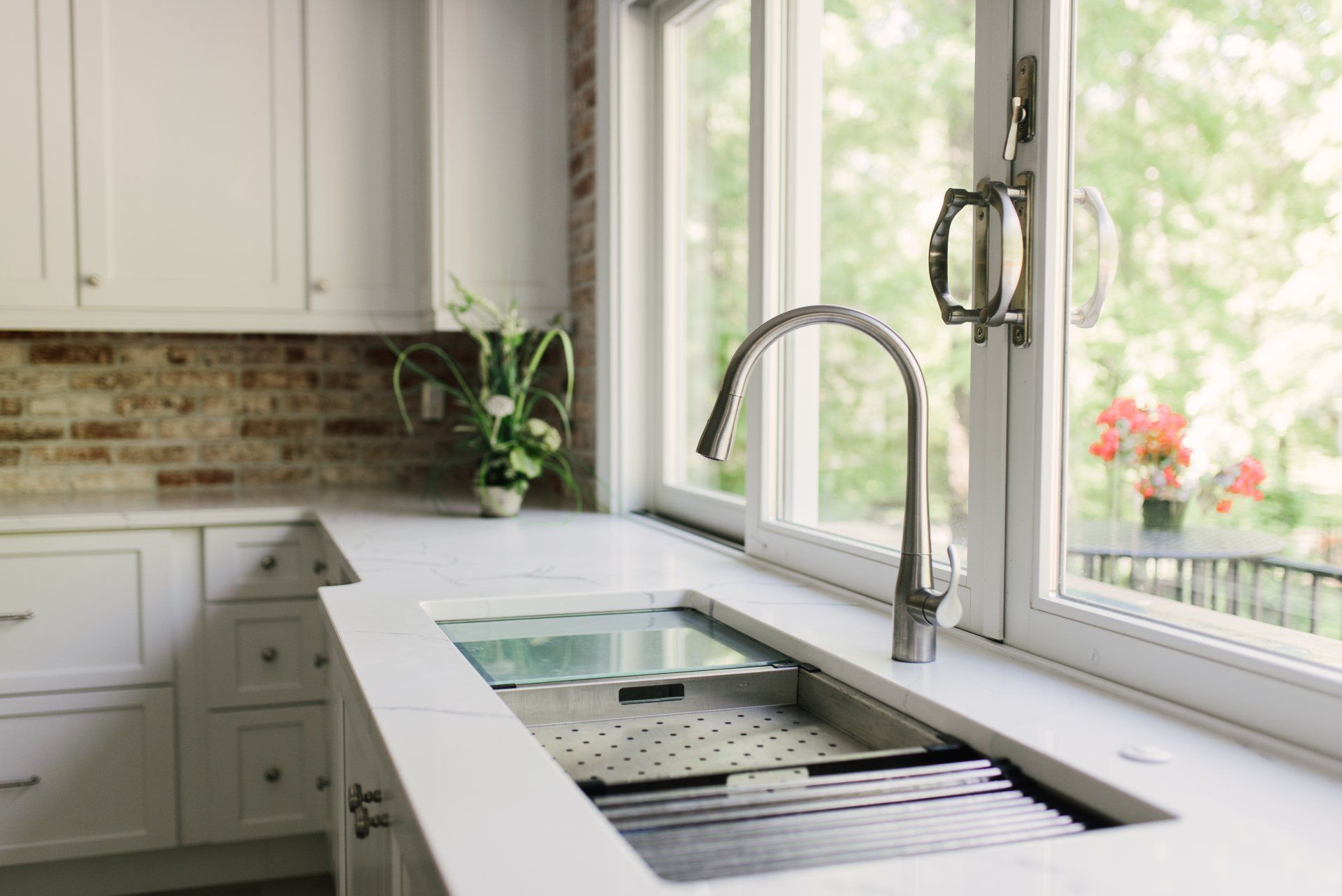 A kitchen with a stainless steel sink and a window.