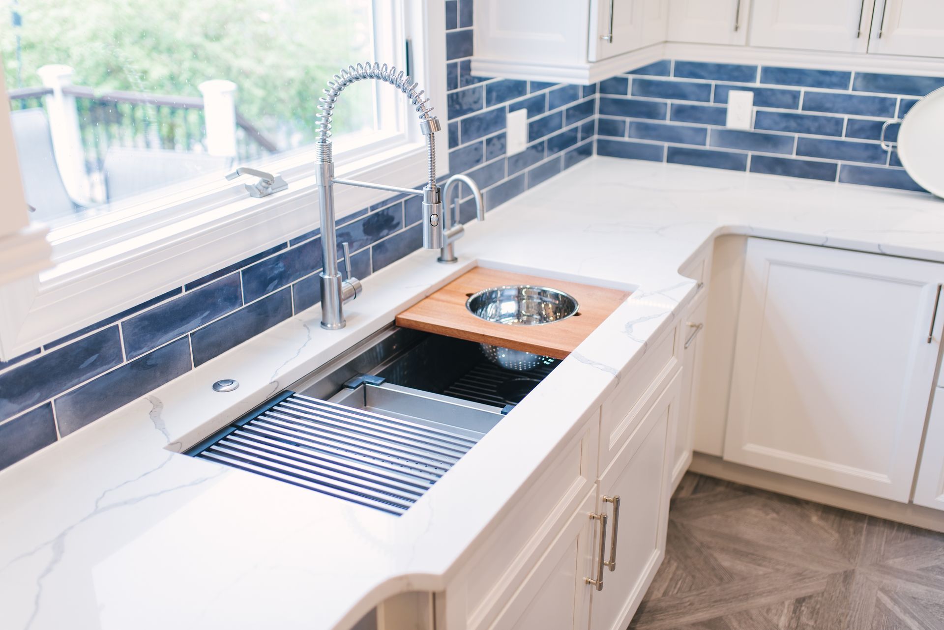 A kitchen with a sink , cabinets , and a window.