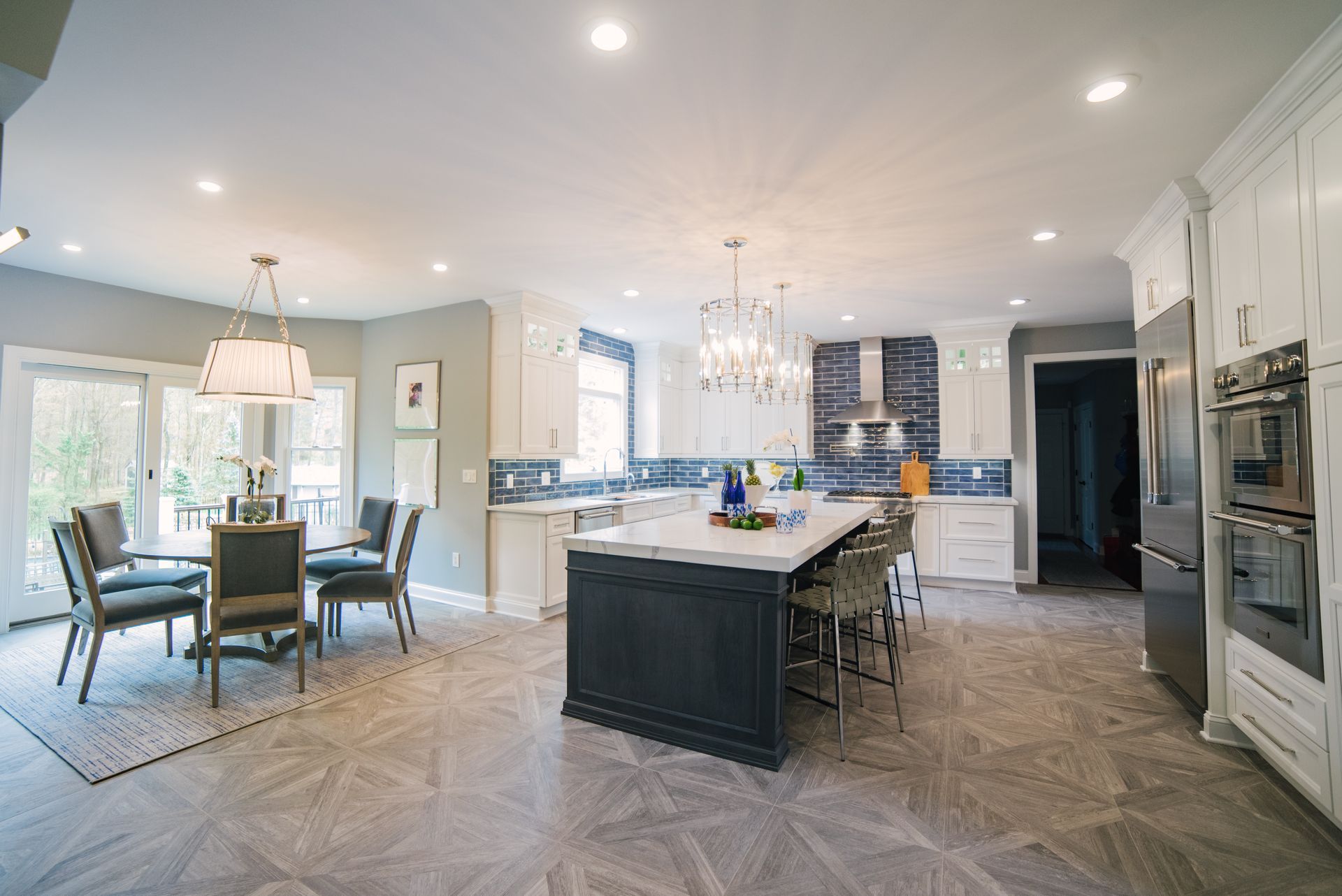 A large kitchen with a large island in the middle and a dining room.