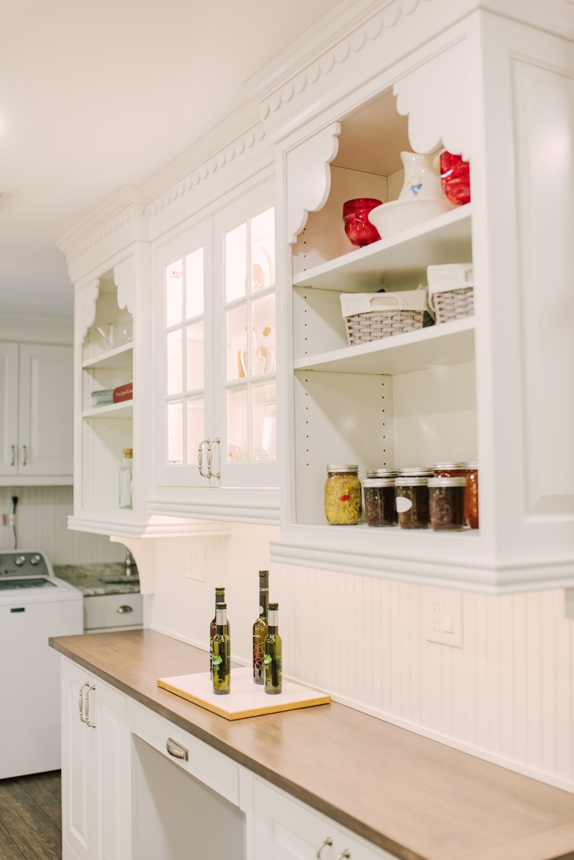 A kitchen with white cabinets and wooden counter tops