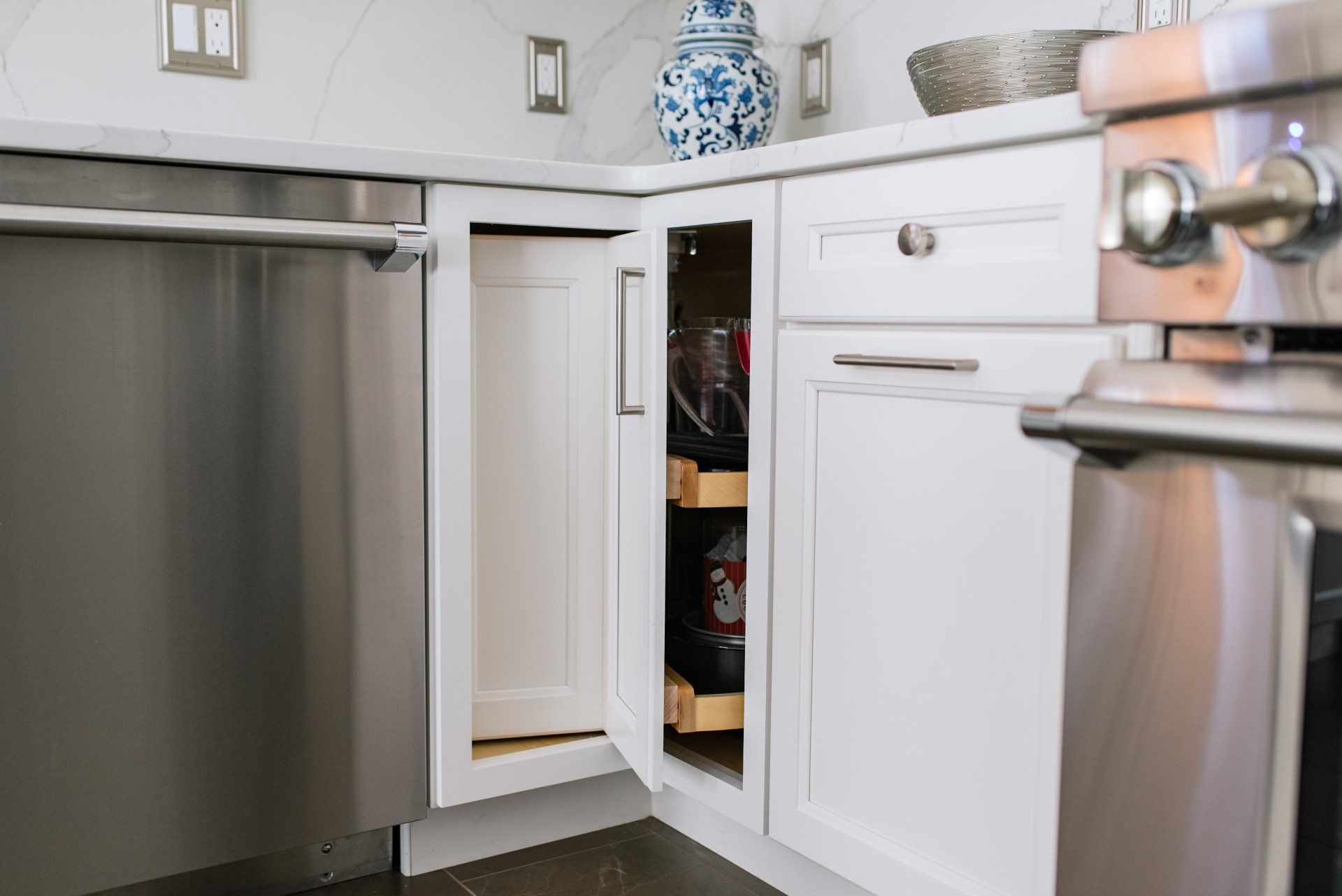 A kitchen with white cabinets , stainless steel appliances , and a stainless steel dishwasher.