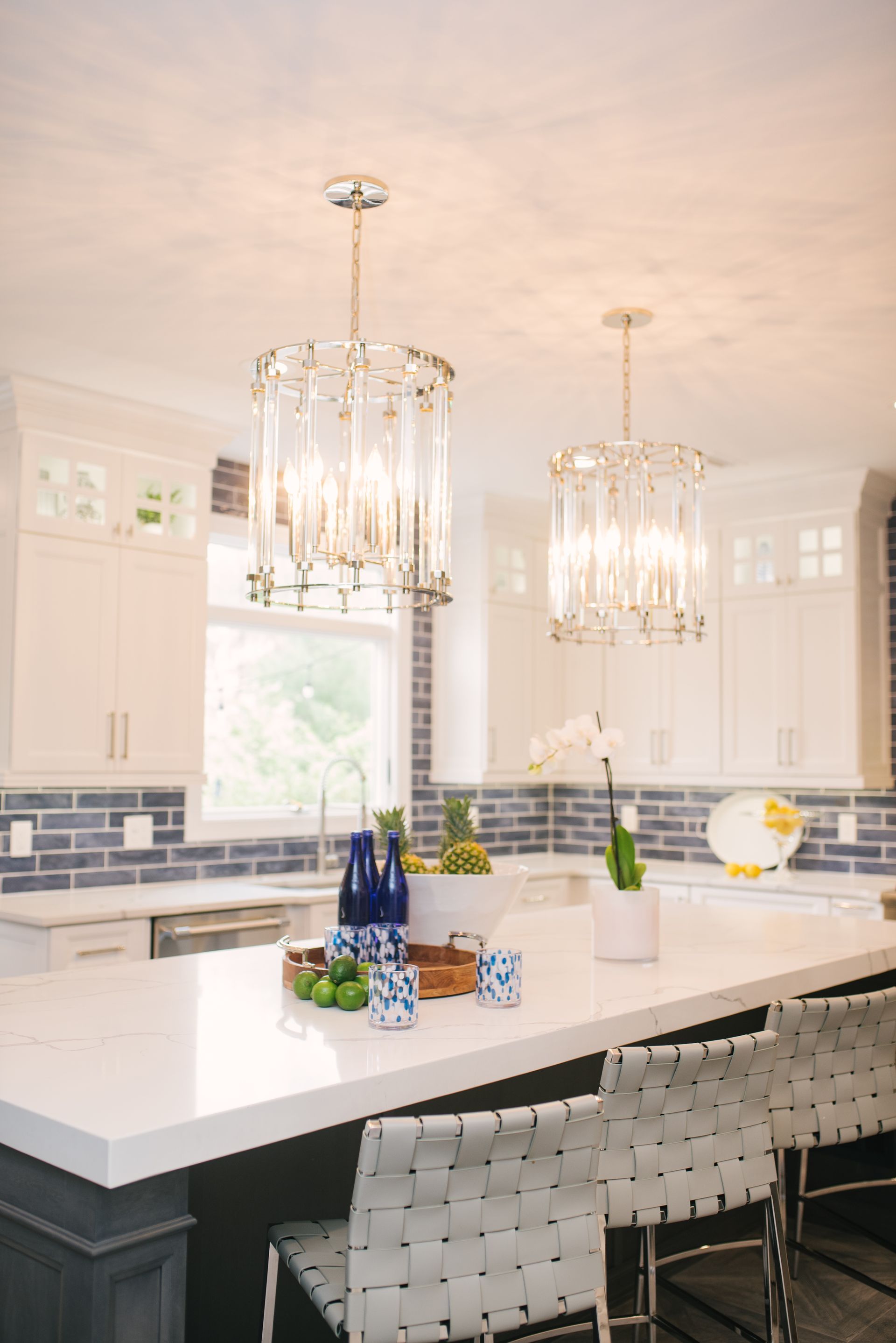 A kitchen with a large island and a chandelier hanging from the ceiling.