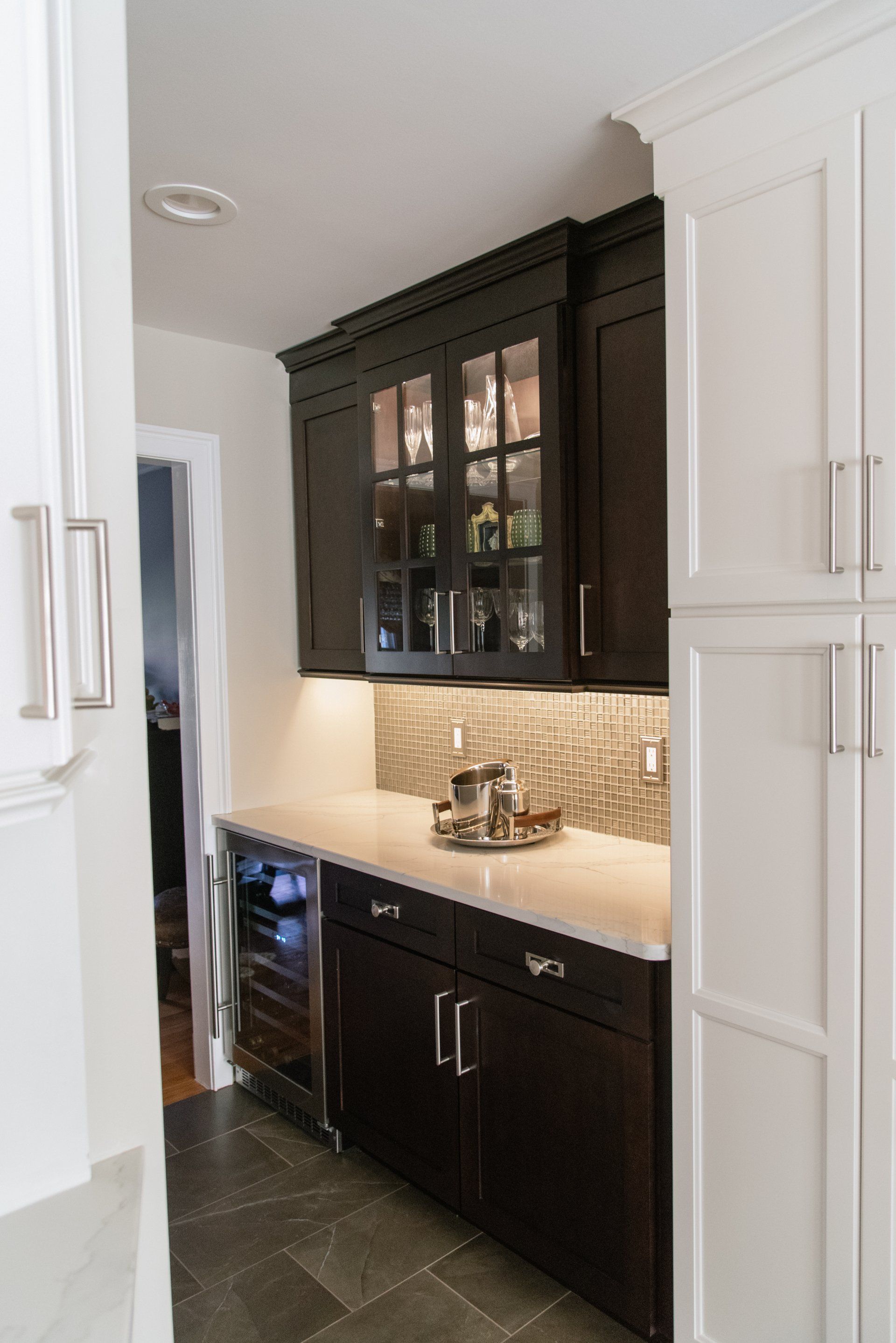 A kitchen with dark cabinets and white counter tops
