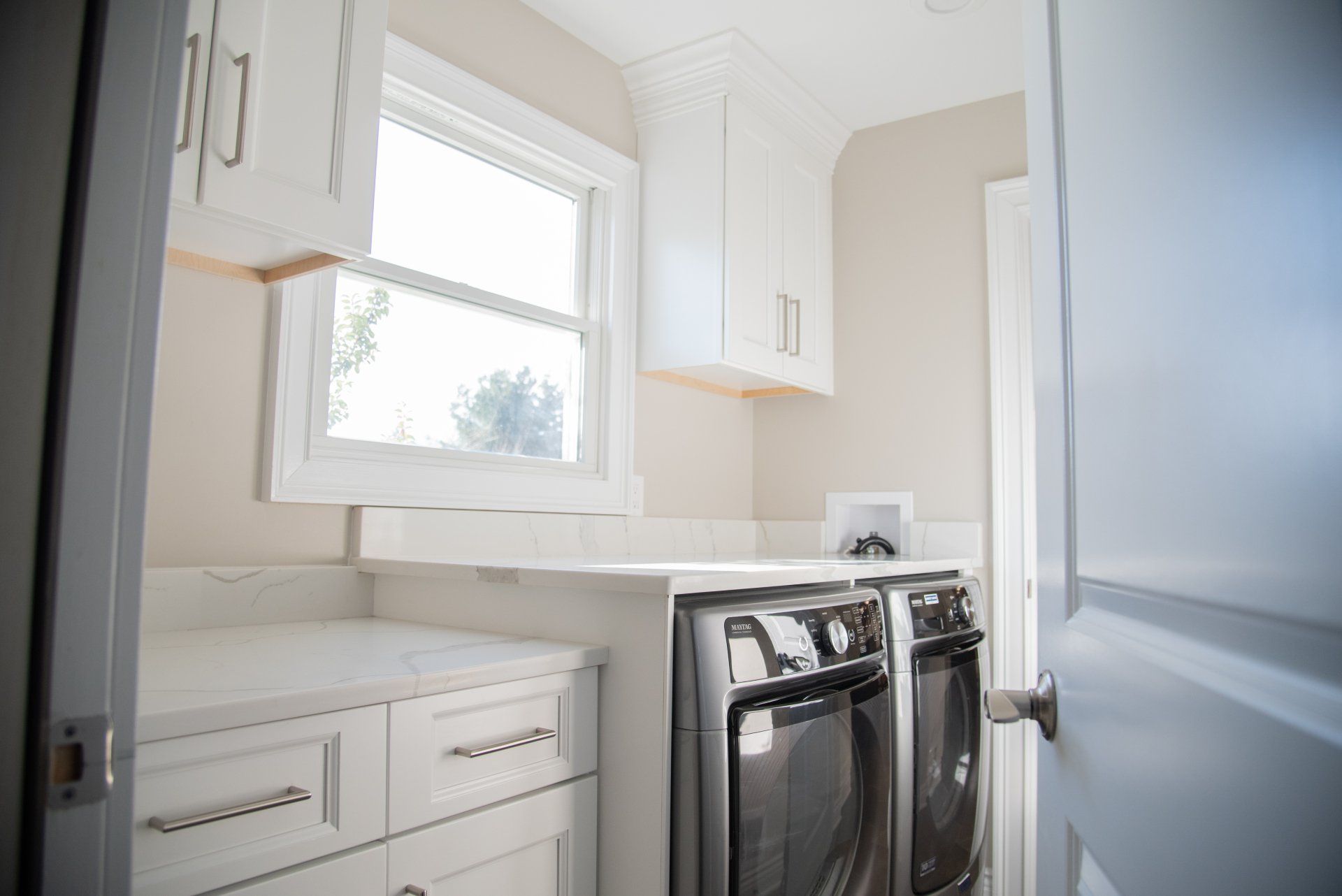 A laundry room with a washer and dryer and a window.
