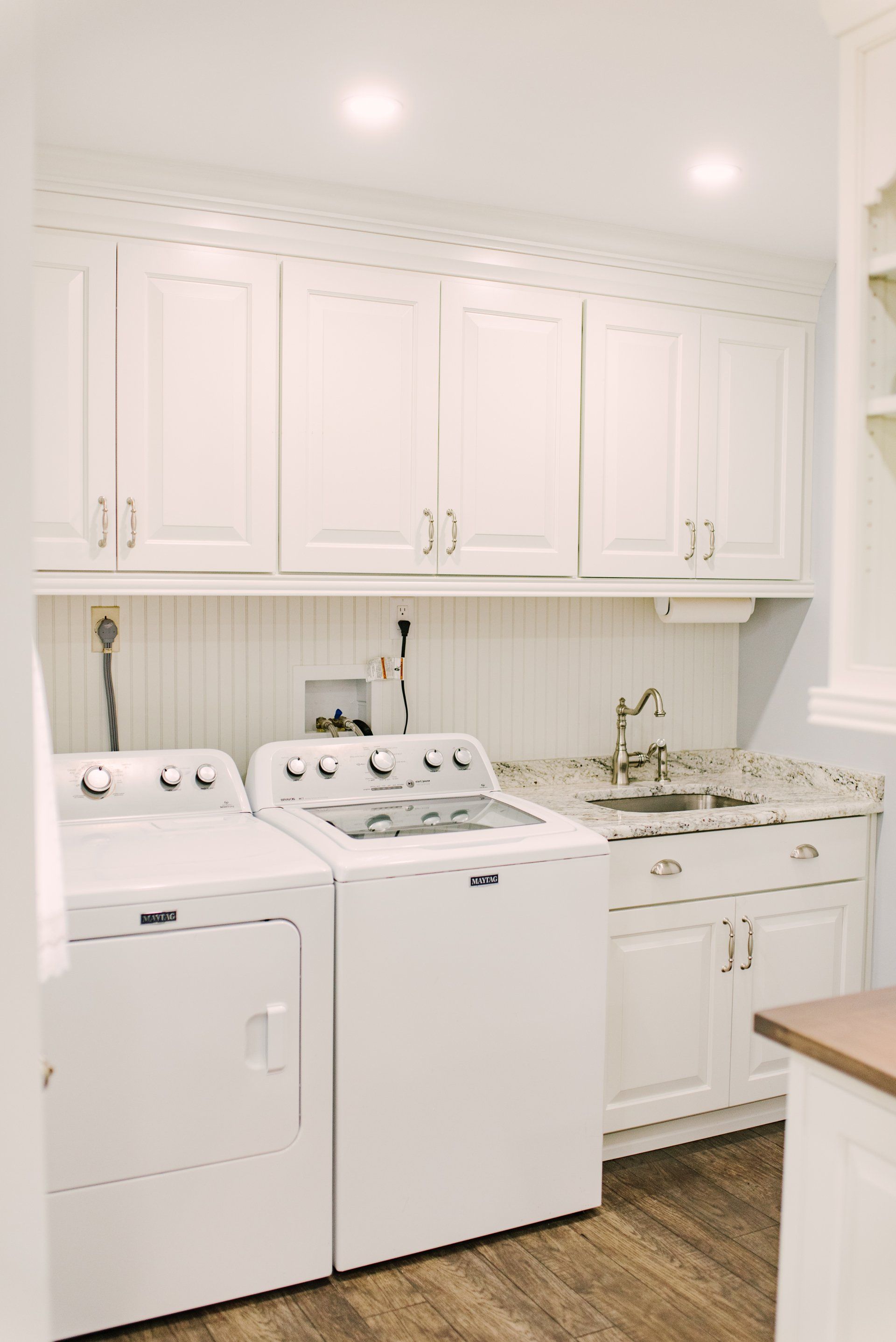 A laundry room with a washer and dryer and a sink.