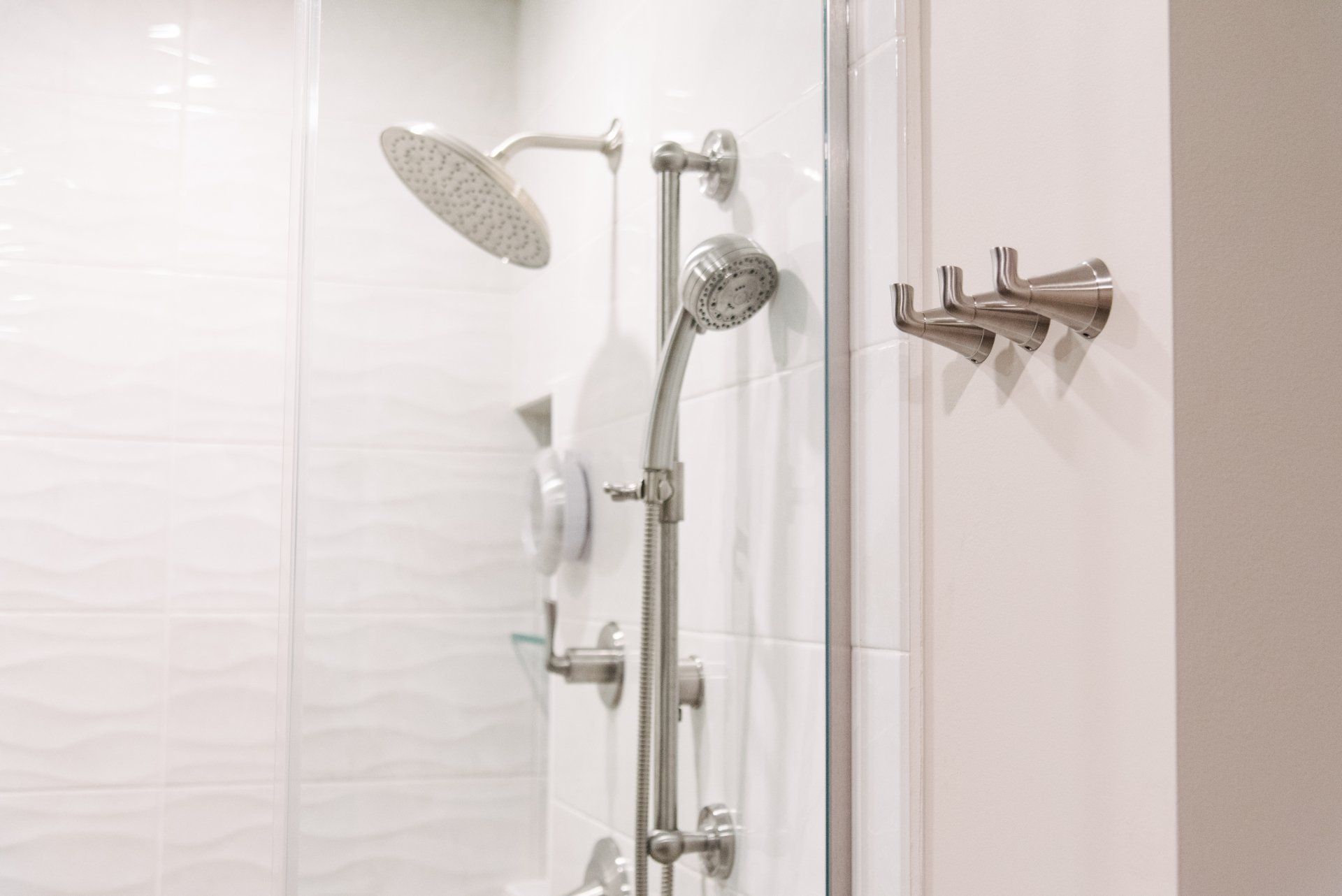 A shower with a glass door and a shower head.